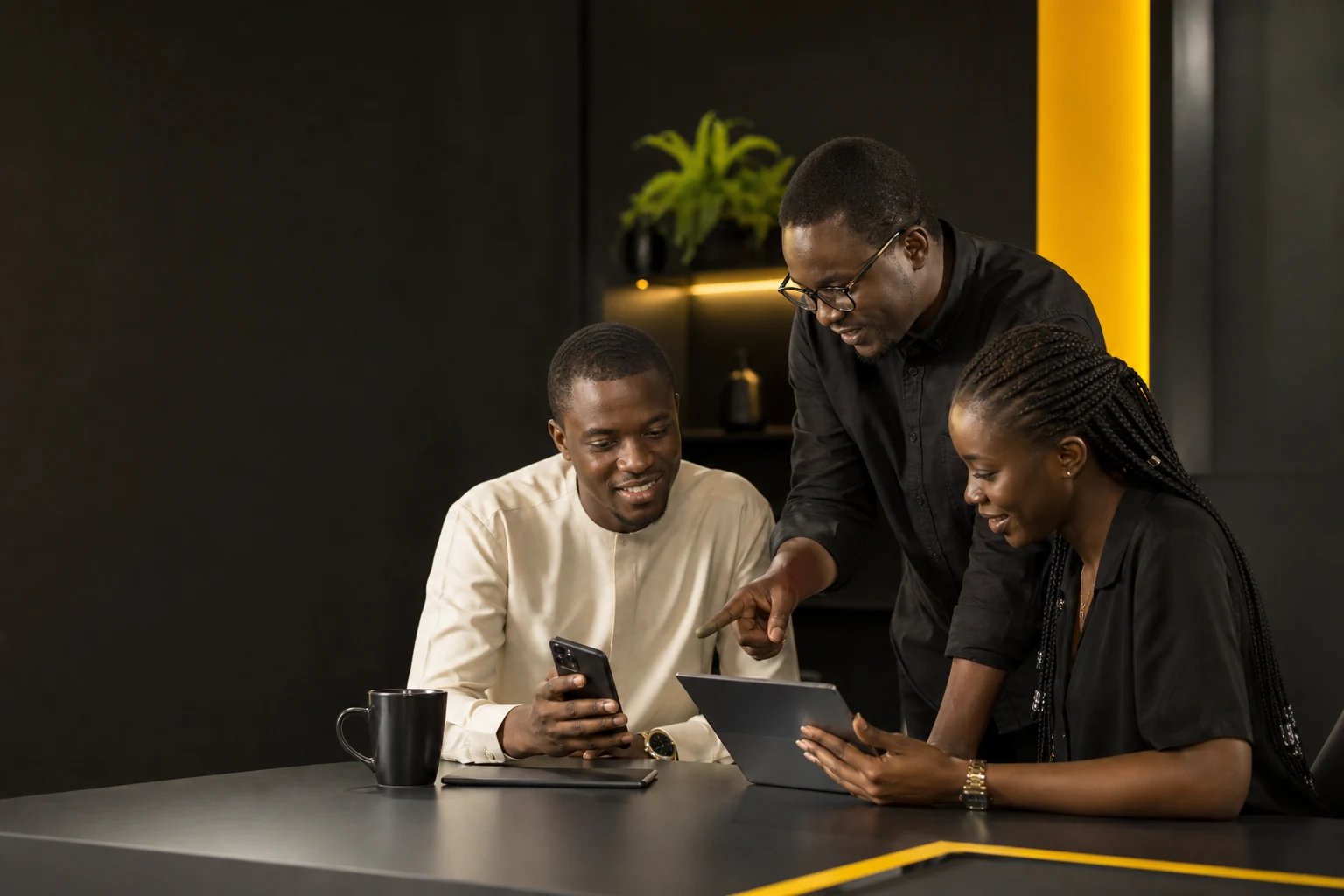 Équipe produit sénégalaise testant une application mobile sur téléphone et tablette